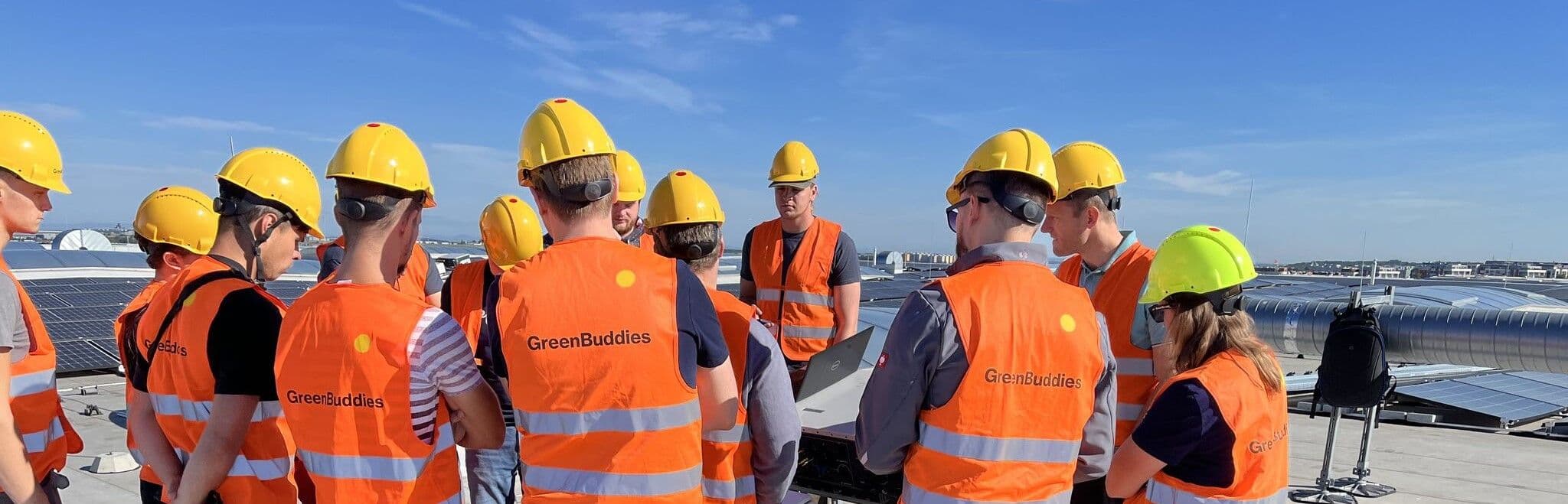 Greenbuddies tým na střešní FVE v bezpečnostních helmách a vestách